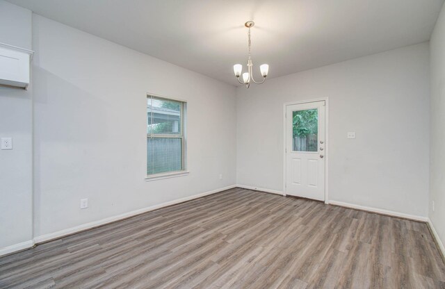 8718 Scott St Unit A B, Houston, TX 77051 - unfurnished room featuring healthy amount of natural light, wood finished floors, and a chandelier