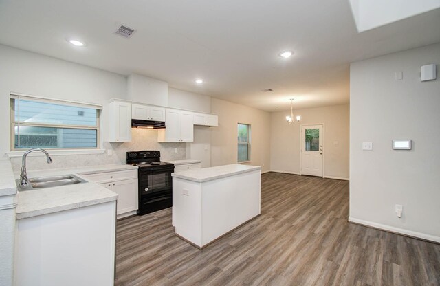 8718 Scott St Unit A B, Houston, TX 77051 - kitchen with black electric range oven, under cabinet range hood, light wood-style flooring, a chandelier, and light countertops