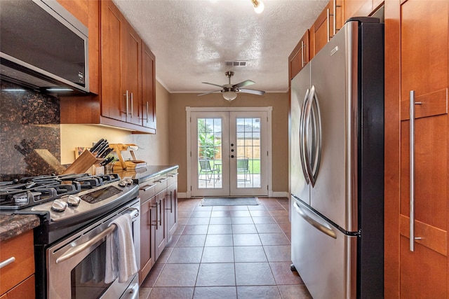 1417 S Heron Dr, Seabrook, TX 77586 - kitchen with appliances with stainless steel finishes, brown cabinetry, ceiling fan, decorative backsplash, and a textured ceiling