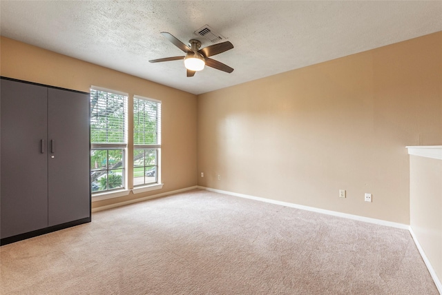 1417 S Heron Dr, Seabrook, TX 77586 - unfurnished bedroom featuring light carpet, a textured ceiling, and a ceiling fan