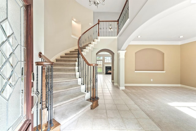 14210 Hansons Creek Ct, Houston, TX 77044 - foyer entrance with arched walkways, stairway, tile patterned flooring, a warm lit fireplace, and recessed lighting
