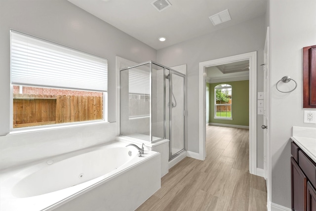 14210 Hansons Creek Ct, Houston, TX 77044 - bathroom featuring vanity, a whirlpool tub, a stall shower, and wood finished floors