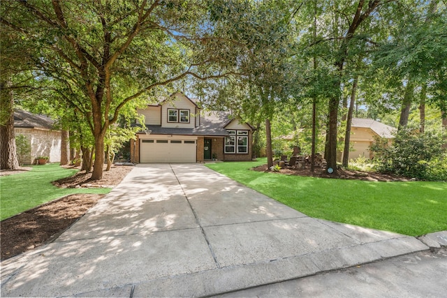 248 S Pathfinders Cir, The Woodlands, TX 77381 - traditional-style house featuring an attached garage, driveway, a front lawn, and brick siding