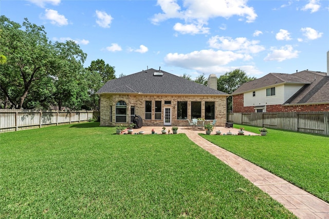 17706 Riata Lake Dr, Cypress, TX 77433 - rear view of house featuring a patio, brick siding, a chimney, a fenced backyard, and roof with shingles