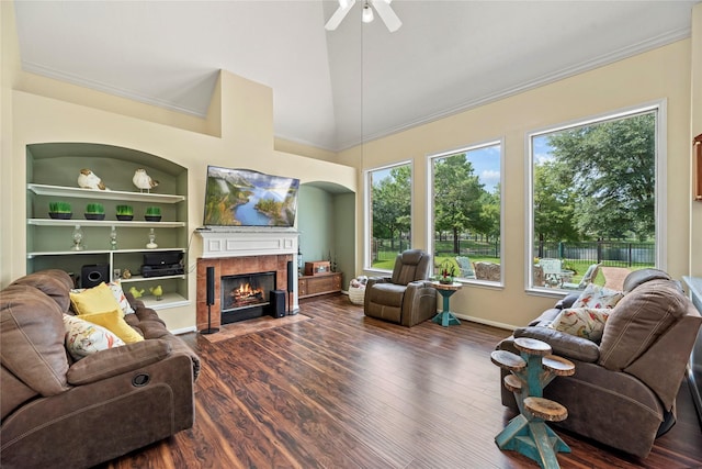17706 Riata Lake Dr, Cypress, TX 77433 - living room featuring built in features, a tiled fireplace, ceiling fan, wood finished floors, and crown molding