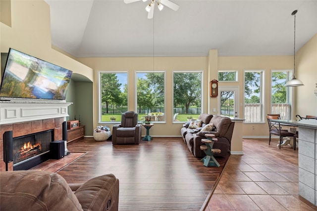 17706 Riata Lake Dr, Cypress, TX 77433 - living area with a tiled fireplace, vaulted ceiling, ceiling fan, ornamental molding, and wood finished floors