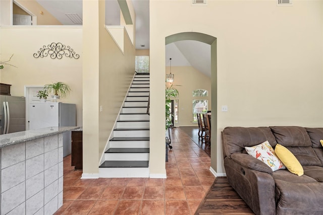 17706 Riata Lake Dr, Cypress, TX 77433 - staircase with high vaulted ceiling, arched walkways, and tile patterned flooring