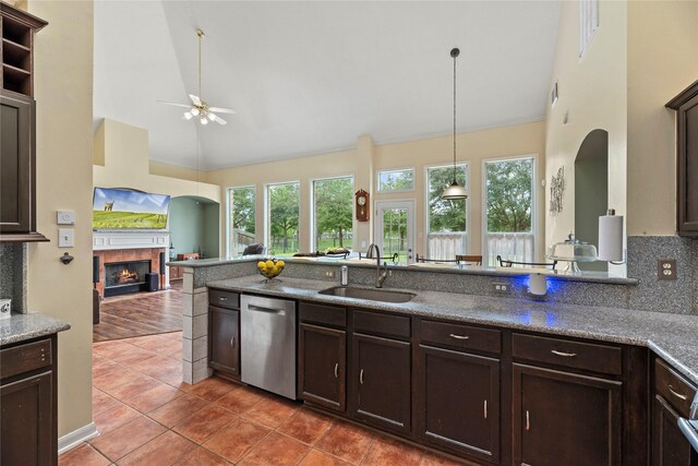 17706 Riata Lake Dr, Cypress, TX 77433 - kitchen featuring dishwasher, ceiling fan, dark brown cabinets, tile patterned floors, and a tiled fireplace