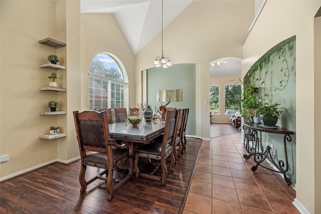 17706 Riata Lake Dr, Cypress, TX 77433 - dining room featuring healthy amount of natural light, arched walkways, high vaulted ceiling, a chandelier, and dark wood-style flooring