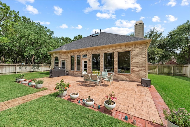 17706 Riata Lake Dr, Cypress, TX 77433 - rear view of property with brick siding, a chimney, a patio area, a fenced backyard, and a shingled roof