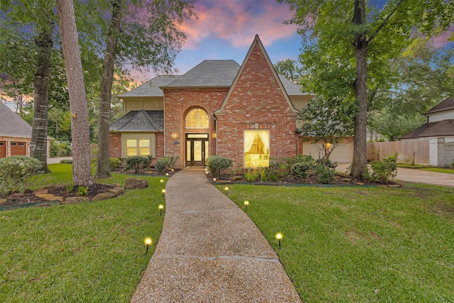 9311 Windrush Dr, Spring, TX 77379 - traditional-style home featuring french doors, brick siding, roof with shingles, and driveway