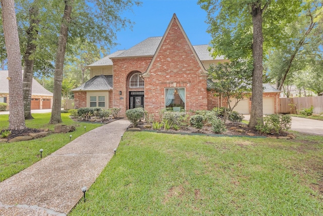 9311 Windrush Dr, Spring, TX 77379 - view of front of house with a shingled roof, brick siding, driveway, and a garage