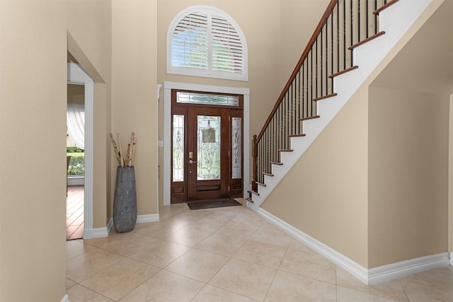 9311 Windrush Dr, Spring, TX 77379 - entryway with healthy amount of natural light, a high ceiling, tile patterned flooring, and stairway