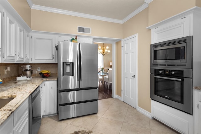 9311 Windrush Dr, Spring, TX 77379 - kitchen with appliances with stainless steel finishes, ornamental molding, a chandelier, white cabinetry, and tasteful backsplash