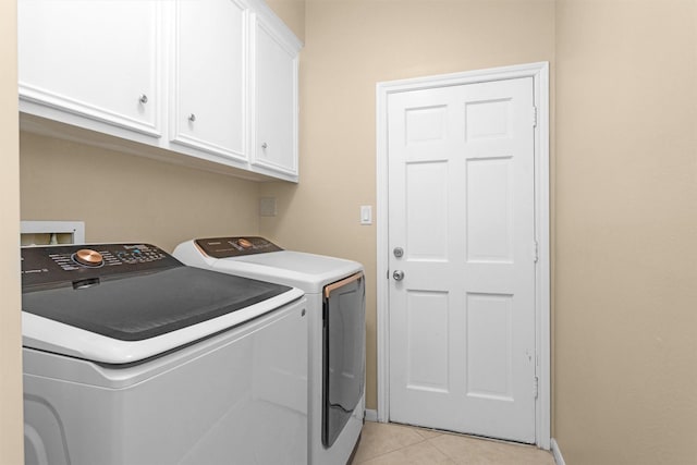 9311 Windrush Dr, Spring, TX 77379 - laundry room featuring washing machine and clothes dryer, cabinet space, and light tile patterned floors