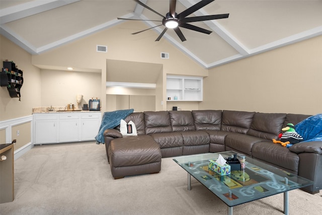 9311 Windrush Dr, Spring, TX 77379 - living area featuring light colored carpet, bar with sink, ceiling fan, beamed ceiling, and high vaulted ceiling