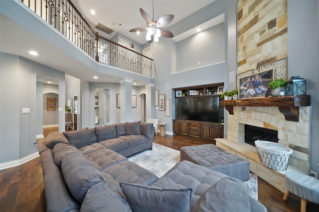 14014 Lakewood Crossing Blvd, Houston, TX 77070 - living room featuring a ceiling fan, a towering ceiling, a stone fireplace, dark wood-style flooring, and arched walkways