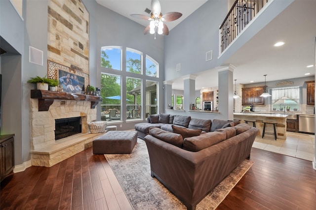 14014 Lakewood Crossing Blvd, Houston, TX 77070 - living room featuring a ceiling fan, light wood-style flooring, a stone fireplace, and a towering ceiling