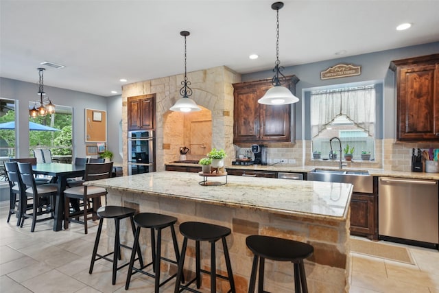14014 Lakewood Crossing Blvd, Houston, TX 77070 - kitchen featuring appliances with stainless steel finishes, a center island, tasteful backsplash, light stone countertops, and recessed lighting