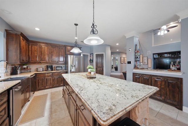 14014 Lakewood Crossing Blvd, Houston, TX 77070 - kitchen with appliances with stainless steel finishes, backsplash, a center island, light stone counters, and a ceiling fan