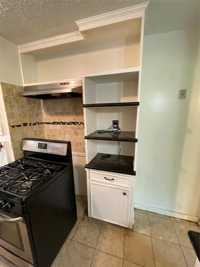 7539 Carothers St, Houston, TX 77028 - kitchen featuring stainless steel gas range oven, open shelves, ornamental molding, decorative backsplash, and dark countertops
