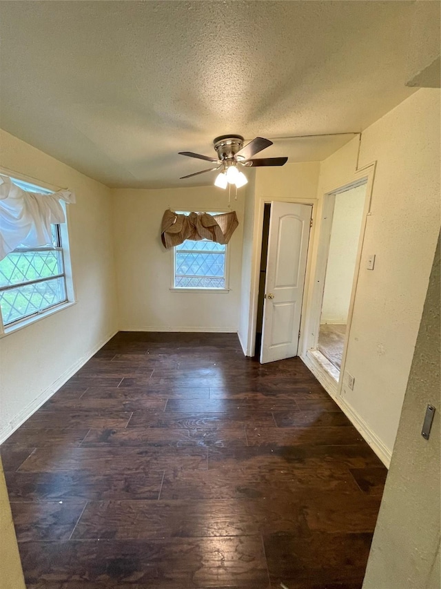 7539 Carothers St, Houston, TX 77028 - empty room with plenty of natural light, dark wood finished floors, a textured ceiling, and ceiling fan