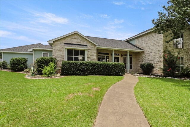 105 Sally Lake Ct, Angleton, TX 77515 - view of front of house with stone siding, a front yard, and a shingled roof