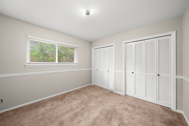 6055 Golden Forest Dr, Houston, TX 77092 - unfurnished bedroom featuring two closets and carpet floors