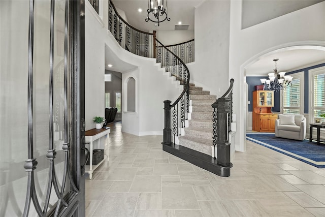 1002 Pleasant Pines Ln, Pinehurst, TX 77362 - entryway featuring a chandelier, arched walkways, stairs, and a towering ceiling