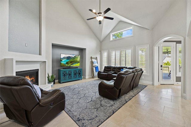 1002 Pleasant Pines Ln, Pinehurst, TX 77362 - living area featuring a ceiling fan, high vaulted ceiling, a glass covered fireplace, and arched walkways