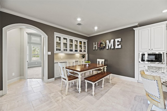 1002 Pleasant Pines Ln, Pinehurst, TX 77362 - dining room featuring ornamental molding, arched walkways, and recessed lighting