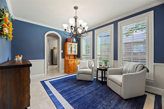 1002 Pleasant Pines Ln, Pinehurst, TX 77362 - sitting room featuring arched walkways, ornamental molding, a chandelier, and wainscoting