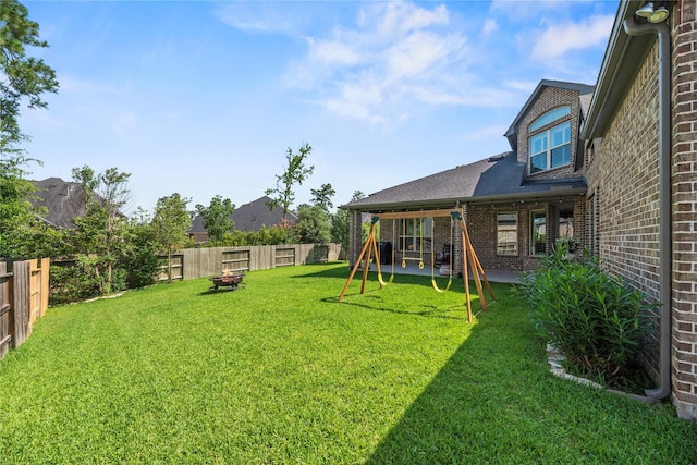 1002 Pleasant Pines Ln, Pinehurst, TX 77362 - fenced backyard featuring a playground and a fire pit