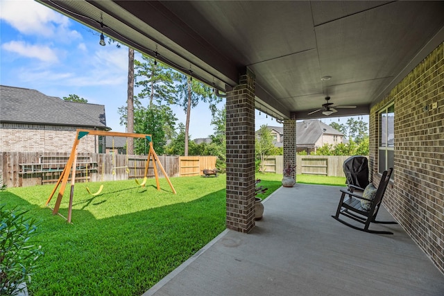 1002 Pleasant Pines Ln, Pinehurst, TX 77362 - fenced backyard with a playground, ceiling fan, and a patio
