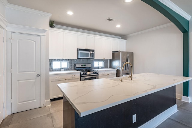 2919 Gillespie St, Houston, TX 77020 - kitchen with appliances with stainless steel finishes, arched walkways, crown molding, white cabinets, and tasteful backsplash