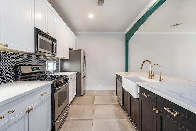 2919 Gillespie St, Houston, TX 77020 - kitchen featuring stainless steel appliances, white cabinetry, crown molding, backsplash, and light stone counters
