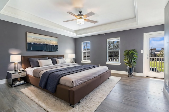 2919 Gillespie St, Houston, TX 77020 - bedroom with a tray ceiling, access to outside, wood finished floors, and a ceiling fan