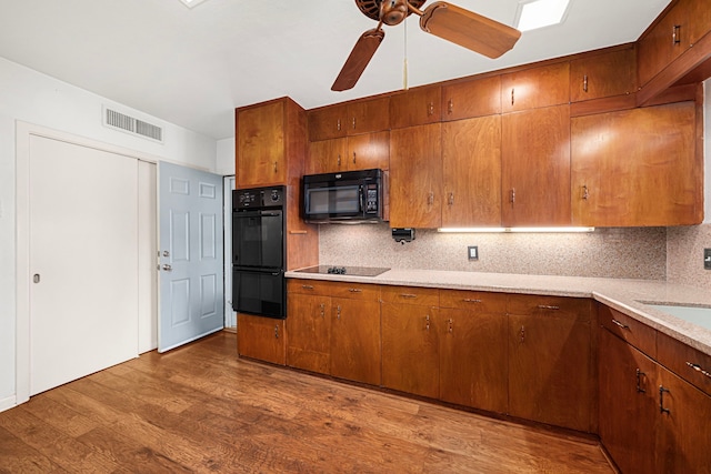 1908 Milam St, Columbus, TX 78934 - kitchen featuring black appliances, tasteful backsplash, light countertops, and wood finished floors