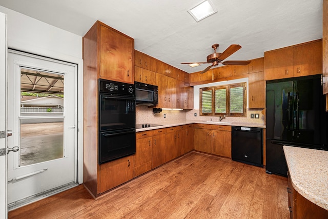 1908 Milam St, Columbus, TX 78934 - kitchen featuring black appliances, brown cabinets, light countertops, light wood-style flooring, and ceiling fan