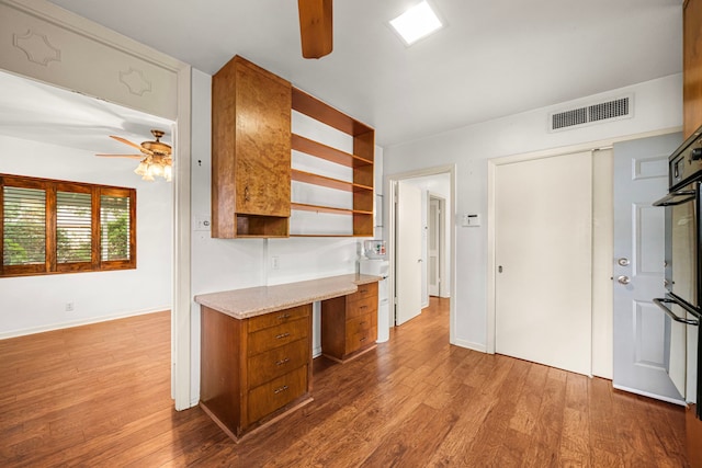 1908 Milam St, Columbus, TX 78934 - kitchen featuring a ceiling fan, open shelves, brown cabinets, and dark wood-style flooring
