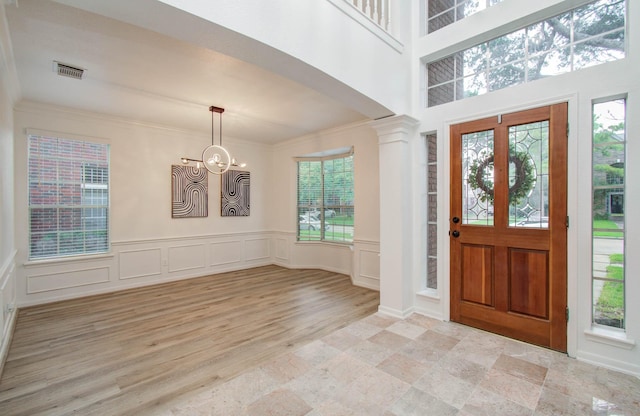 20531 Spring Rose Dr, Katy, TX 77450 - foyer featuring a chandelier, plenty of natural light, a decorative wall, ornamental molding, and wainscoting
