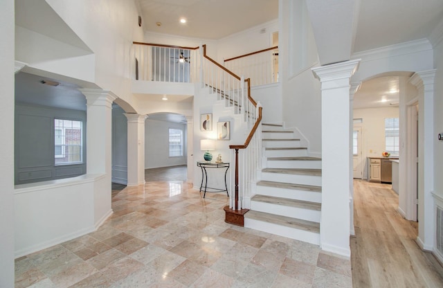 20531 Spring Rose Dr, Katy, TX 77450 - entryway featuring arched walkways, ornate columns, ornamental molding, stairs, and a towering ceiling