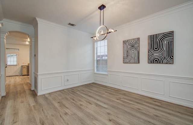 20531 Spring Rose Dr, Katy, TX 77450 - empty room with decorative columns, crown molding, arched walkways, plenty of natural light, and light wood-style floors