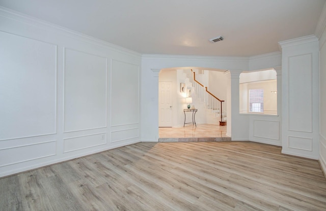 20531 Spring Rose Dr, Katy, TX 77450 - empty room with a decorative wall, decorative columns, light wood finished floors, stairway, and ornamental molding