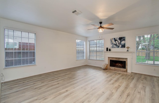 20531 Spring Rose Dr, Katy, TX 77450 - unfurnished living room with light wood-style flooring, ceiling fan, and a tiled fireplace