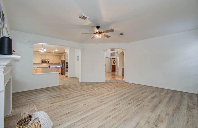 20531 Spring Rose Dr, Katy, TX 77450 - unfurnished living room with a ceiling fan, light wood-type flooring, decorative columns, and arched walkways