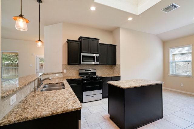 8934 Finnery Dr, Tomball, TX 77375 - kitchen featuring appliances with stainless steel finishes, a kitchen island, tasteful backsplash, dark cabinets, and a peninsula