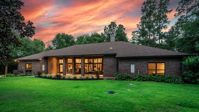 15608 Queen Victoria Ct, Montgomery, TX 77316 - back of property at dusk with brick siding, a lawn, a chimney, and a shingled roof