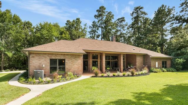 15608 Queen Victoria Ct, Montgomery, TX 77316 - rear view of house featuring a lawn, brick siding, a chimney, and roof with shingles