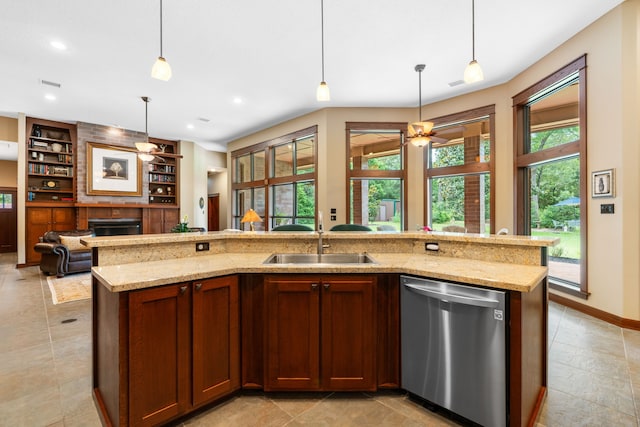 15608 Queen Victoria Ct, Montgomery, TX 77316 - kitchen with stainless steel dishwasher, a fireplace, light stone counters, a ceiling fan, and built in features
